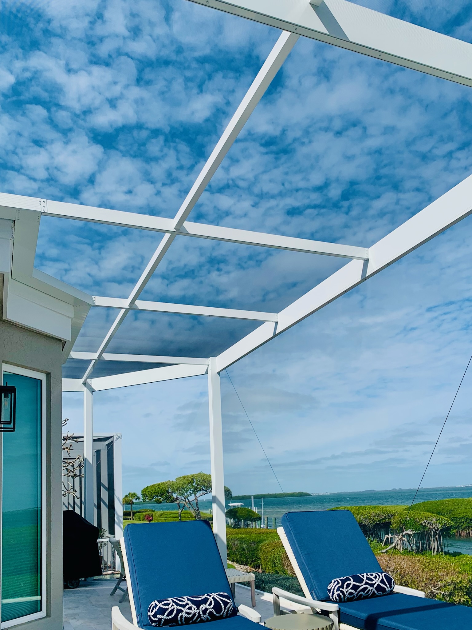 Waterfront screened patio with lounge chairs