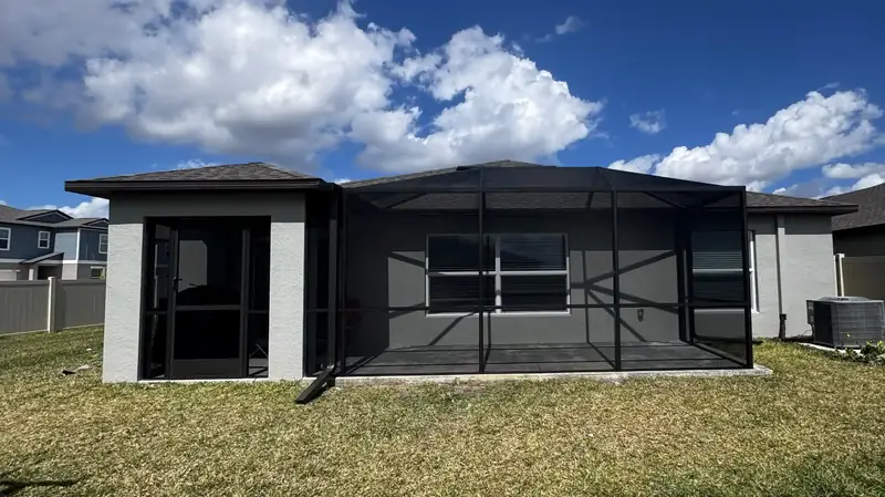 Refurbished pool cage with dark screens and freshly painted aluminum frame
